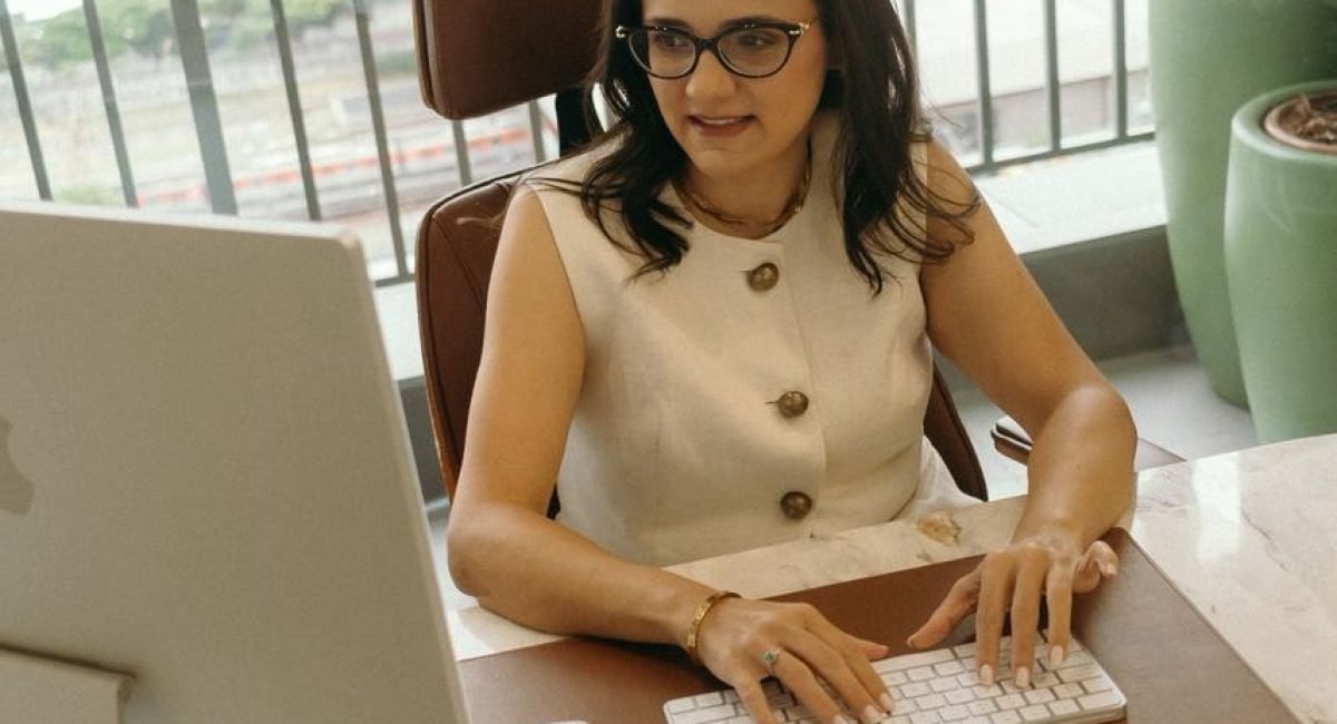 dra. mychelly carvalho em seu consultório, olhando para o computador